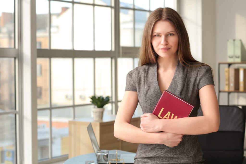 Woman in grey top and serious face holding a book preparing a Notary Public Schedule
