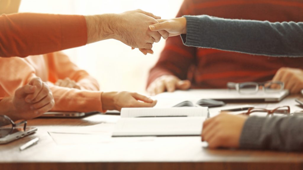 Mobile notary shaking hands after meeting in a conference room. How to become a mobile notary.