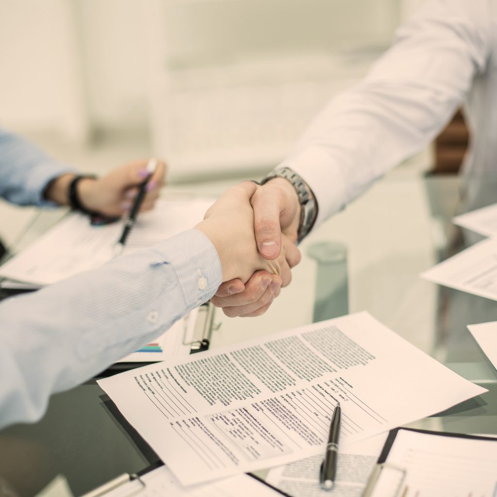 reliable handshake business partners after signing new contract in the workplace in the office.the photo has a empty space for your text. Mobile notary public