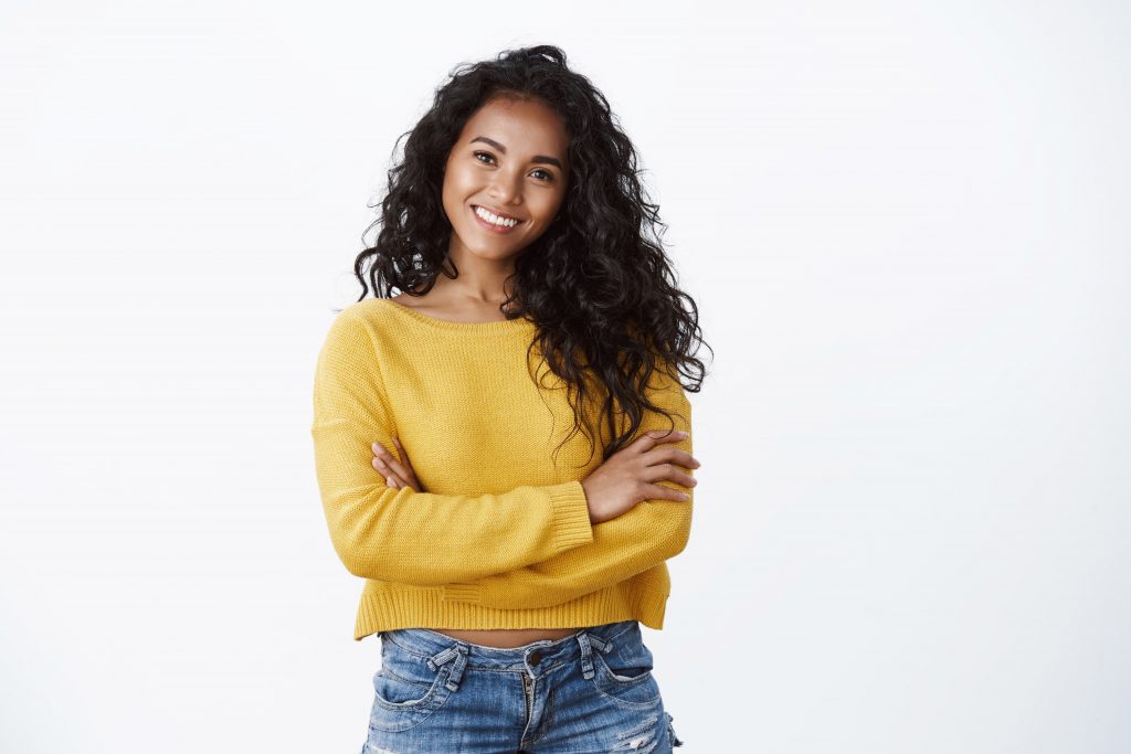 confident woman wearing a yellow sweater posing with her arms crossed. how to make money while making a difference.